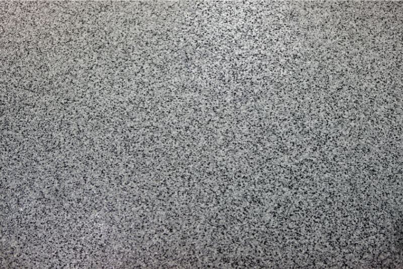 An exposed aggregate concrete with epoxy flooring over it